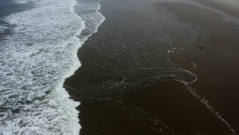 Olas-Del-Océano-Pacífico-Rompiendo-En-Cámara-Lenta-En-La-Playa-De-Arena,-Costa-De-Oregon