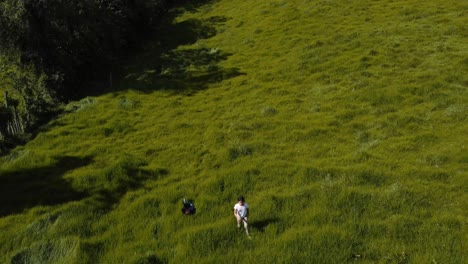 Vista-De-Drones-De-Niños-Jugando-Y-Corriendo-En-La-Hierba-Alta-Al-Atardecer