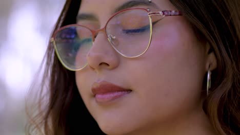 Close-up-shot-of-a-woman-with-glasses-and-open-hair,-turning-towards-the-camera-with-a-captivating-look,-exuding-confidence-and-allure