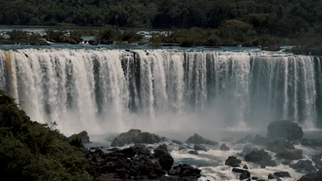Water-Flowing-Down-On-Iguazu-Waterfalls-With-Rocks-In-Downstream