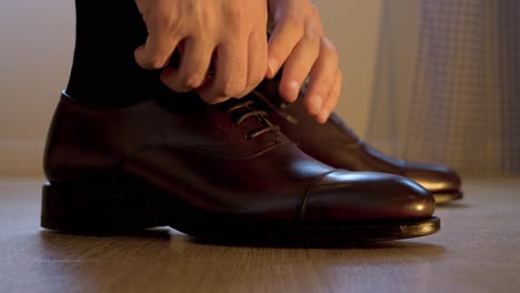 Close-up-of-a-man-tying-his-black-leather-wedding-shoes