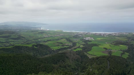 Aerial-shot-picturesque-nature-of-Sete-Cidades-in-Azores-with-lush-green-hills,-abandoned-Monte-Palace-hotel-on-hilltop