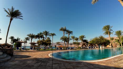 Wide-angle-static-shot-of-hotel-resort-with-palm-trees-swimming-pool-beachside-egypt-dahab-travel-destination