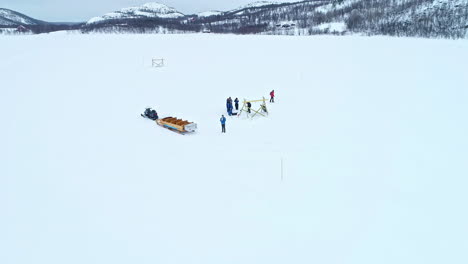 Group-fishing-for-king-crab-in-Kirkenes-Norway-aerial-snowy-landscape