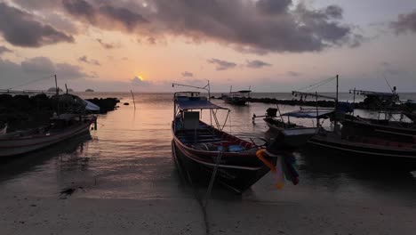 Multiple-Boats-Docked-Alongside-Shore-During-Beautiful-Golden-Sunset,-Thailand