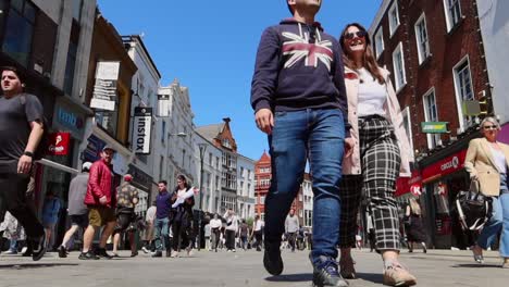 Happy-couple-walking-and-holding-hands-on-bustling-Grafton-Street,-Dublin