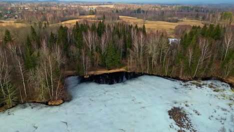 Frozen-Lake-In-Fall-Forest---Aerial-Drone-Shot