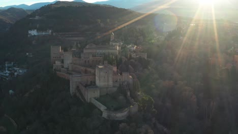 Aerial-Drone-of-Alhambra-Medieval-Complex,-Islamic-Palace-On-The-Hilltop-At-Sunrise-In-Granada,-Andalusia,-Spain