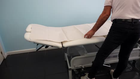 Physiotherapist-preparing-the-stretcher-for-a-rehab-session-inside-a-clinic
