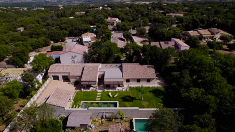 Drone-rotation-of-a-magnificent-Provençal-house-with-its-small-garden,-deckchairs-and-Bali-stone-swimming-pool