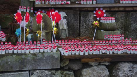 Estatuas-De-Jizo-Guardianes-Con-Pañuelos-Rojos-Mientras-Cae-Nieve-En-El-Templo-De-Yamadera,-Japón