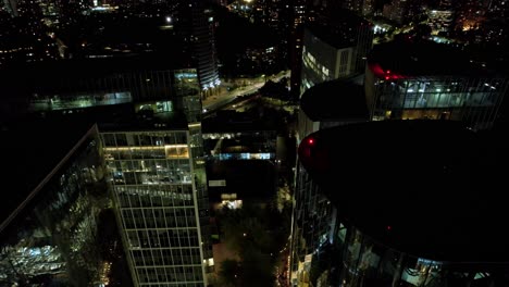 Aerial-view-over-illuminated-buildings,-night-in-Las-Condes,-Santiago-de-Chile