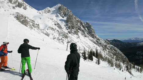 Panoramic-view-of-the-Nassfeld-alpine-ski-resort-on-a-sunny-winter-day,-with-skiers-and-snow-covered-mountain-peaks-in-the-background,-Austria