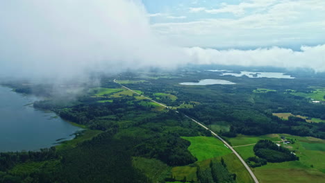 Endless-road-stretching-through-landscape-of-forest,-lakes-and-fields,-aerial-view