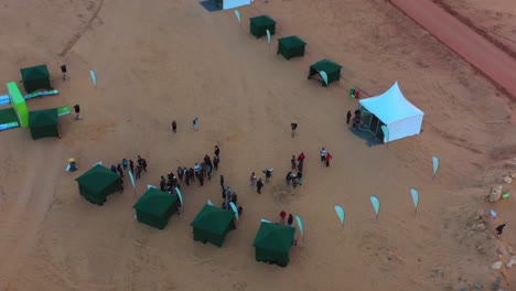 Aerial-view-of-people-at-the-Ecotrail-event,-evening-in-Al-Ula,-Saudi-Arabia---circling,-drone-shot