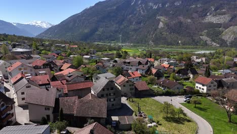 Quaint-quiet-swiss-town-of-Trimmis-with-homes-and-Buildings-and-alps-with-snowy-peak-in-background
