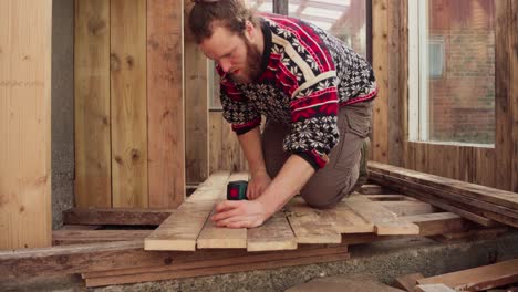 Hombre-Sujetando-Tablones-De-Madera-Con-Tornillo-Usando-Un-Perforador-Inalámbrico-En-Pisos-De-Invernadero