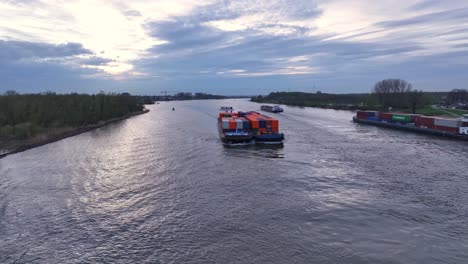 Container-Barges-Traveling-On-River-At-Sunset-In-Zwijndrecht,-Netherlands