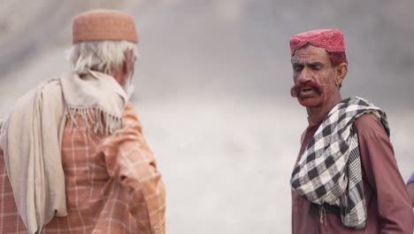 Side-view-of-two-Pakistani-old-men-having-conversation-in-Iftar-Drive-of-Balochistan,-Pakistan