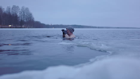 Handheld-shot-of-an-ice-bathing-man-in-his-late-50s-swimming-out