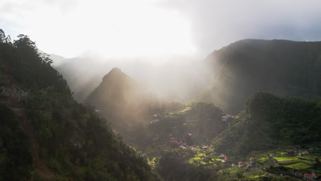 sunshine-on-green-mountain-hazy-valley,-Madeira-nature,-aerial-drone-fly-view