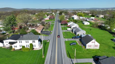 Straight-street-with-driving-cars-in-rural-area-of-american-town