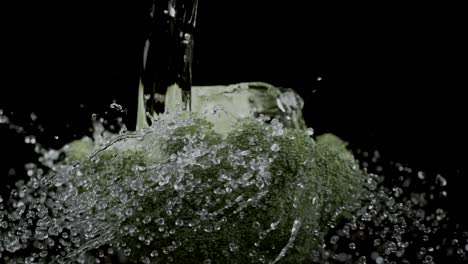 A-rotated-perspective-shows-broccoli-being-rinsed-with-water,-set-against-a-black-background,-illustrating-the-concept-of-vegetable-cleaning