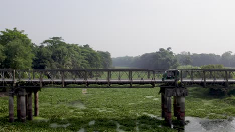 Vehículo-De-Tres-Ruedas-Cruzando-Un-Viejo-Puente-En-Zona-Rural