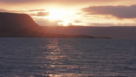 El-Sol-Se-Pone,-Proyectando-Una-Luz-Cálida-Sobre-El-Paisaje-Y-Se-Refleja-En-La-Superficie-Ondulada-Del-Lago-En-Un-Vídeo-A-Cámara-Rápida.