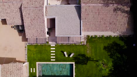 Top-shot-of-a-Provencal-house-in-the-south-of-France-with-its-Bali-stone-swimming-pool-and-its-small-green-garden,-the-tiles-are-from-the-south