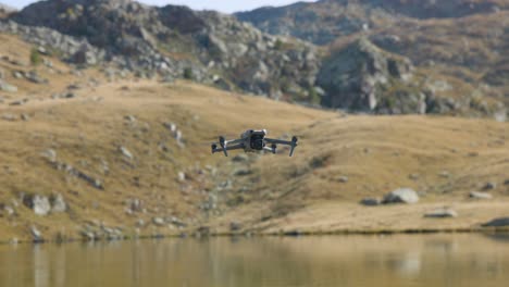 Fliegende-Professionelle-DJI-Air-Drohne,-Die-Im-Statischen-Modus-über-Einem-Bergsee-Schwebt