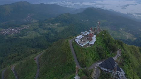 Internet-towers-on-mountain-top-and-majestic-Indonesia-landscape-bellow,-aerial-view