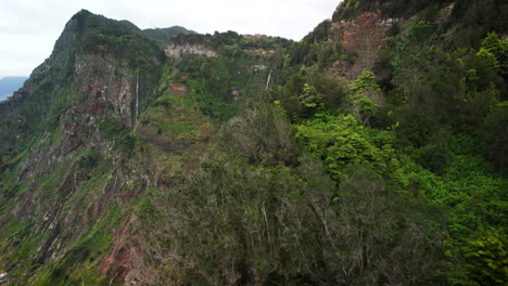 reveal-shot-of-waterfall-Rocha-do-Navio,-Madeiras-green-mountains,-Portugal