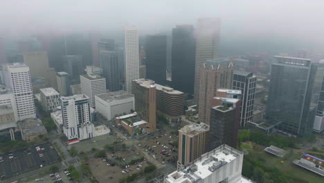 Aerial-view-circling-the-downtown-of-Houston,-Texas,-USA,-covered-in-thick-fog