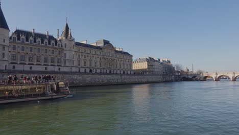 Weite-Aufnahme-Eines-Touristenboots,-Das-An-Sonnigen-Tagen-Auf-Der-Seine-Fährt-Und-Alte-Gebäude-In-Paris-Besucht