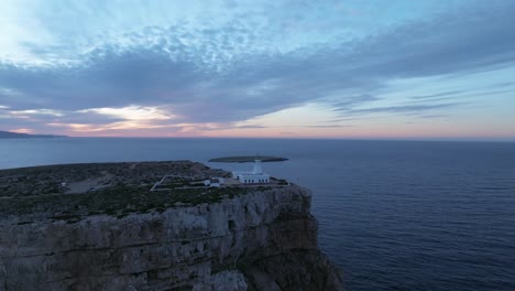 Zoomen-In-Den-Leuchtturm-Von-Cavalleria,-Menorca,-Spanische-Klippe,-Meeresküste,-Drohnenansicht-Des-Sonnenuntergangs,-Spanische-Reisearchitektur