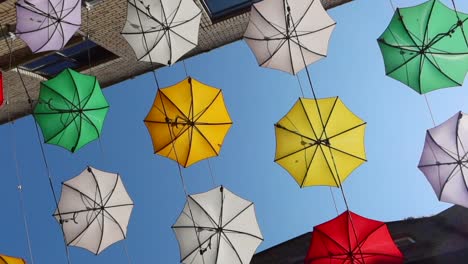Worm's-eye-orbital-view-of-colorful-umbrellas-on-Anne's-Lane,-Dublin,-Ireland