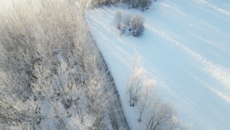 aerial-view-tracking-an-SUV-on-road-through-the-snowy-countryside