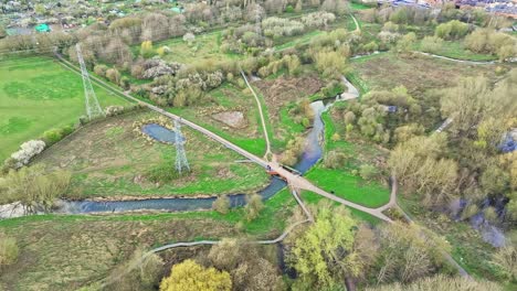 Wasser-Fließt-Im-Natürlichen-Bach-Und-Elektrischer-Strom-Fließt-Durch-Die-Leitungen-Am-Stadtrand-Von-Leicester,-Großbritannien