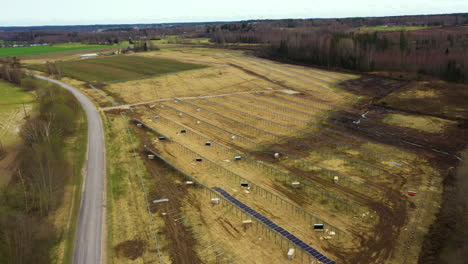 Approaching-aerial-view-of-solar-panel-rows-in-renewable-energy-farm-in-construction