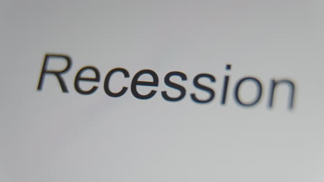 A-close-up-of-a-digital-screen-showing-a-text-cursor-and-"recession"-being-typed
