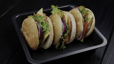 An-array-of-burgers-is-displayed-on-a-sleek-black-plate,-illustrating-the-concept-of-culinary-abundance-and-satisfaction