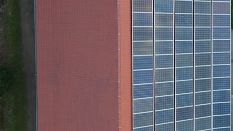 Luftaufnahme-Aus-Der-Vogelperspektive-über-Einem-Roten-Dach,-Dessen-Eine-Seite-Mit-Sonnenkollektoren-Bedeckt-Ist