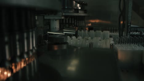 La-Máquina-Produce-Pequeñas-Botellas-De-Envases-De-Plástico,-En-Una-Gran-Fábrica-De-Cadenas.