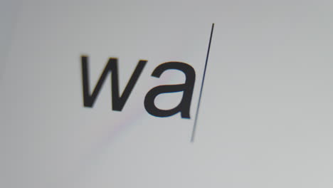 A-close-up-of-a-digital-screen-showing-a-text-cursor-and-"war"-being-typed