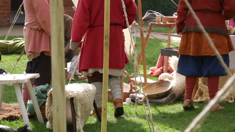 Medieval-group-engaging-around-a-historical-viking-encampment,-with-authentic-costumes-and-props