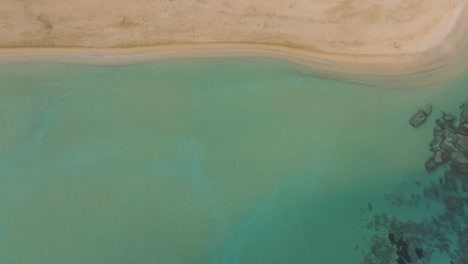 Weißer-Sandstrand,-Luftaufnahme-Von-Oben-Nach-Unten,-Türkisfarbenes-Meerwasser-Entlang-Der-Küste,-Schwenken-Von-Inselchen-In-Blassen-Tönen