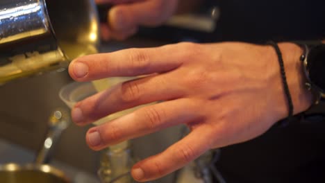 Close-up-4k-shot-on-bartender's-hands-pouring-lemon-juice-in-a-bottle-through-a-plastic-funnel