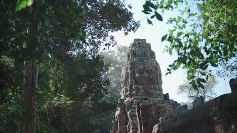 Ancient-Angkor-Wat-temple-ruins-peering-through-lush-foliage-in-bright-daylight