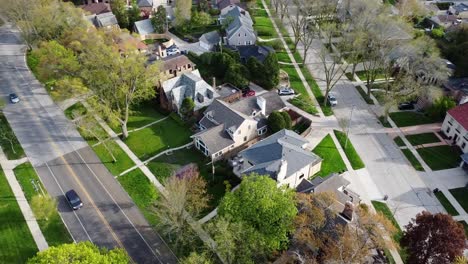 a-large-house-in-a-suburban-neighborhood-with-traffic-passing-by